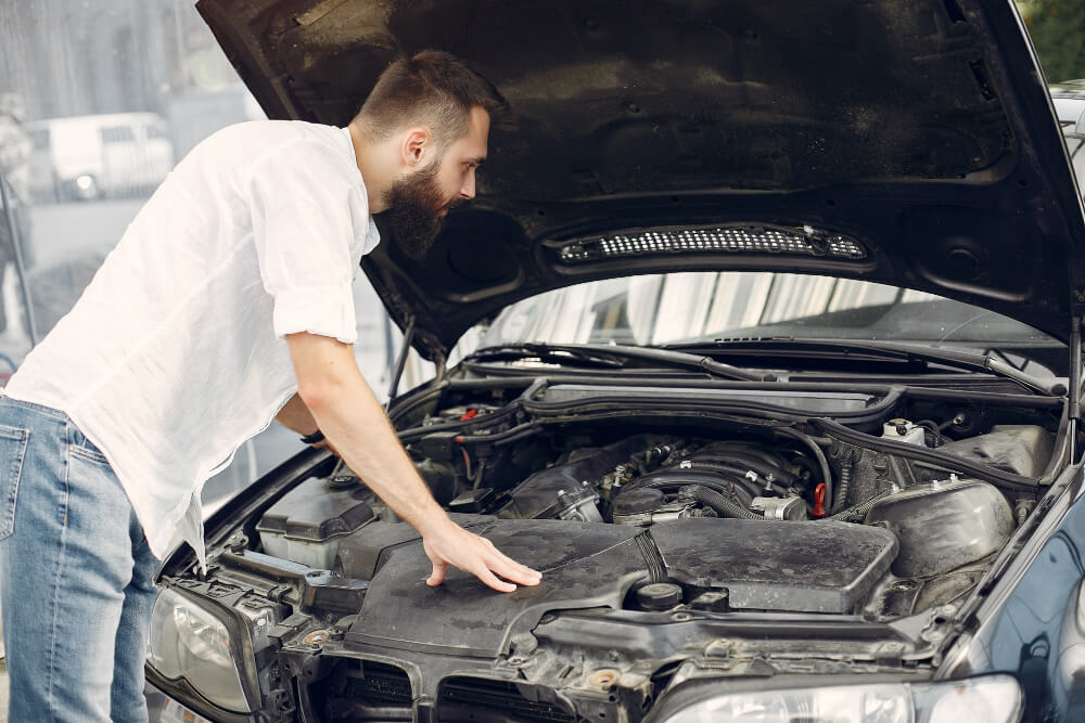 Muž a kapota automobilu